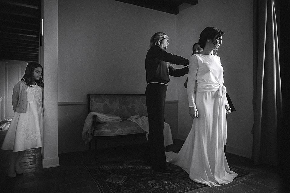 Fotografia della sposa mentre indossa l'abito del matrimonio Fotografia della sposa mentre indossa l'abito del matrimonio